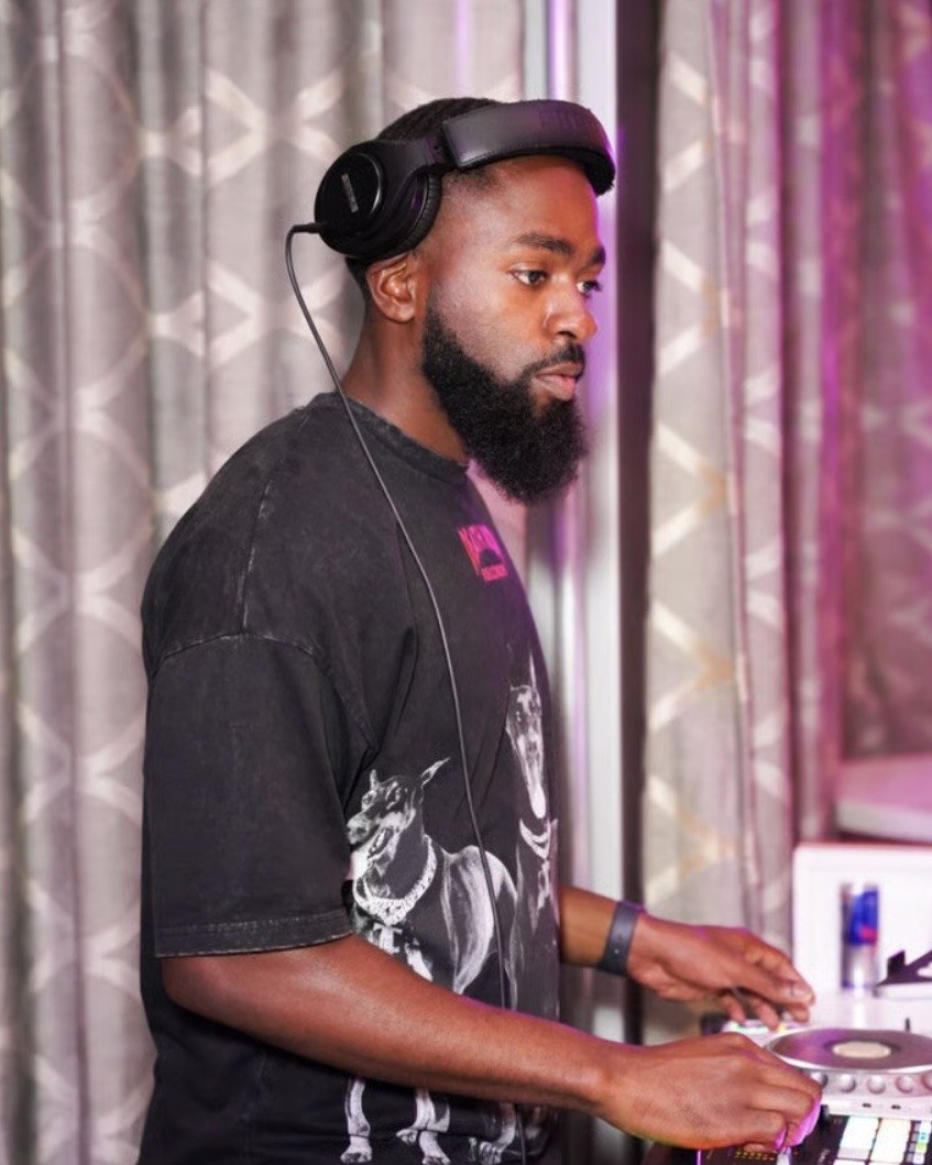 DJ FLYY mixing under purple event lighting